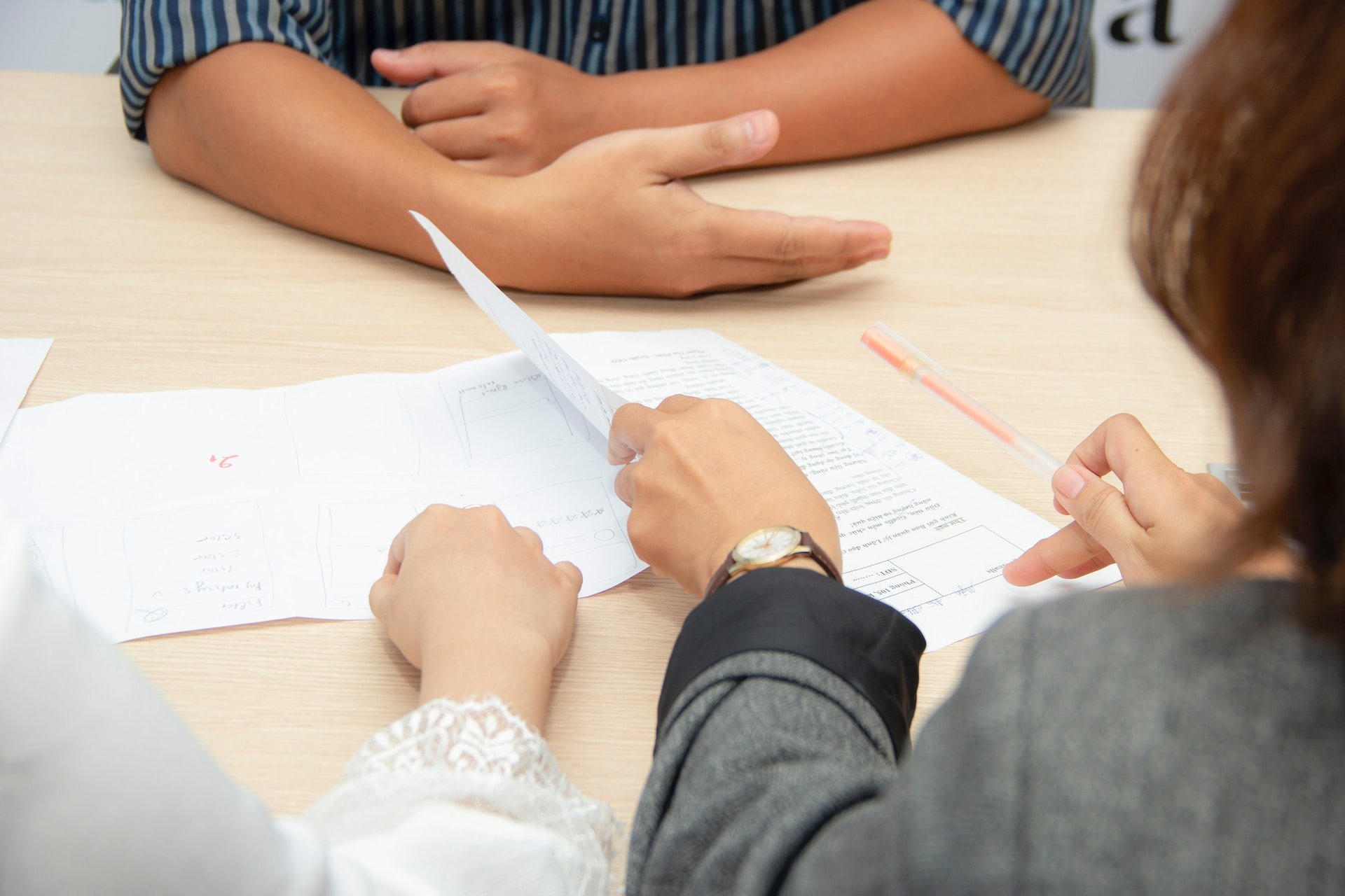 a group of people sitting around a table with papers.